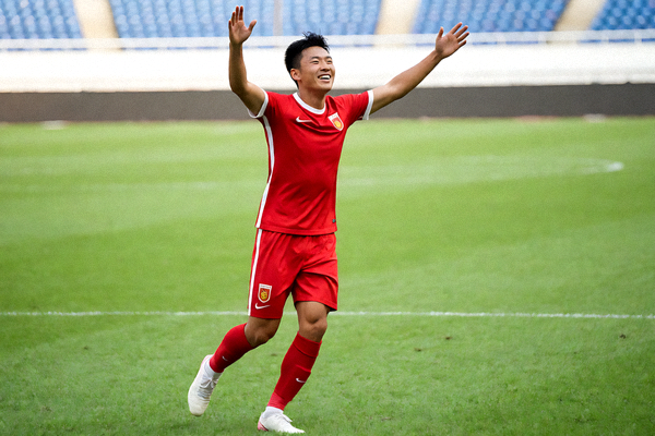 足球运动员在绿茵场上激情庆祝进球的精彩瞬间-绿色足球场背景